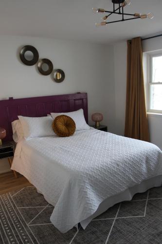 a bedroom with a white bed with a wooden headboard at 4 Guest Suite with Waterfront Views at Fancie's PEC in Belleville