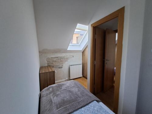 a small bedroom with a bed and a skylight at Apartman Moj mir Jahorina in Jahorina