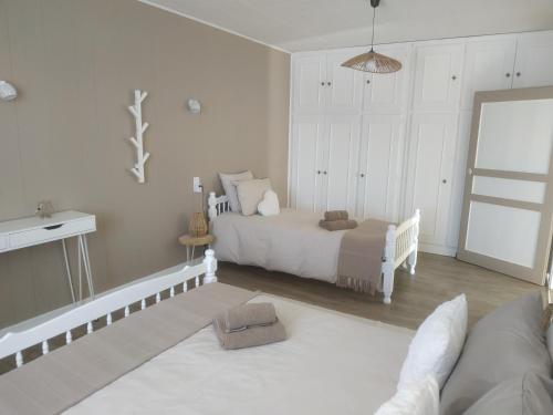 une chambre blanche avec un lit et une chaise dans l'établissement GRAND APPARTEMENT COSY DANS MAISON DE CAMPAGNE, à Saint-Pierre