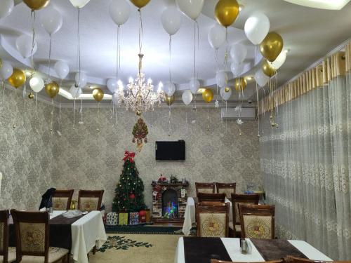 a dining room with a christmas tree and balloons at Luxury Guesthouse in Samarkand