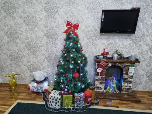 un árbol de Navidad en una sala de estar con chimenea en Luxury Guesthouse, en Samarkand