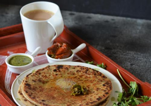 a tray with a plate of food and a cup of coffee at PINETOP RESORT in Khanpur