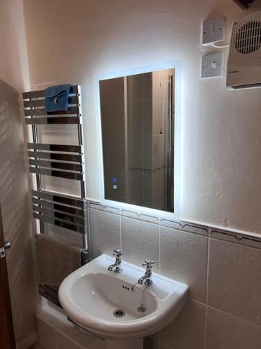 a bathroom with a sink and a mirror at The Drumlins Cottage in Ulverston