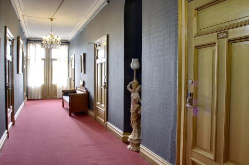 a hallway with a pink carpet and blue walls at Park Hotel Linköping Fawlty Towers in Linköping