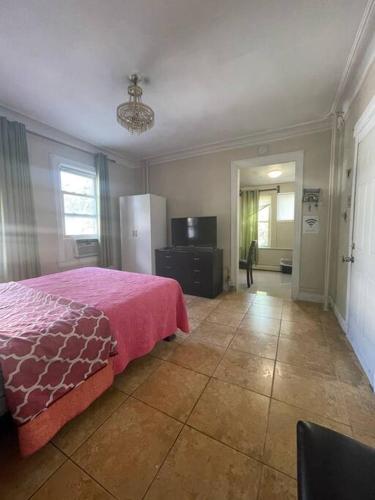 a bedroom with a bed with a pink blanket on it at *PRIVATE* Studio 5 minutes from LGA/ US Open in East Elmhurst