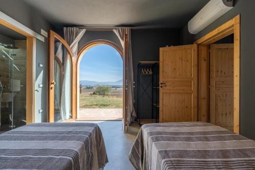 twee bedden in een kamer met een open deur bij Ziarelli Country Loft in Brufa