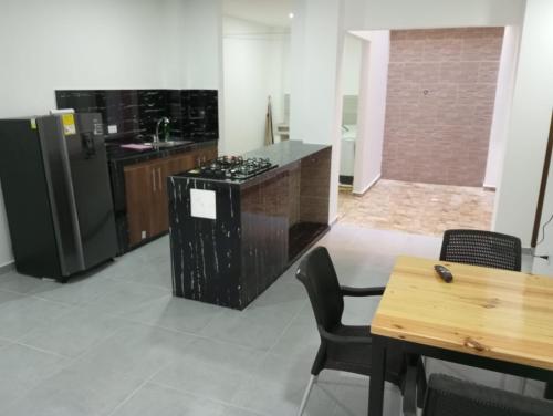 eine Küche mit einem Herd, einem Kühlschrank und einem Tisch in der Unterkunft Apartamento Villa Mary-Coveñas in Coveñas