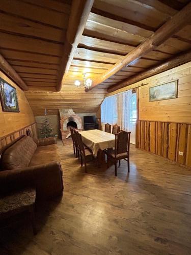 ein Wohnzimmer mit einem Tisch, Stühlen und einem Sofa in der Unterkunft Zarichna Lyks in Slawske