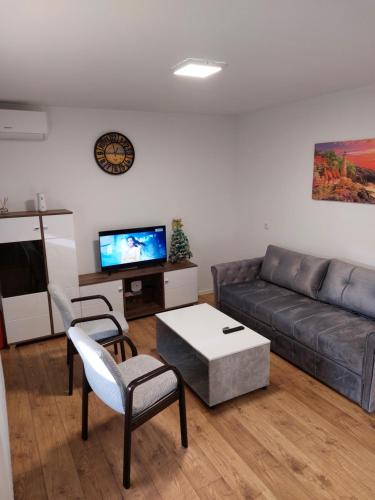 a living room with a couch and a tv at Apartman Aura Prijedor in Prijedor