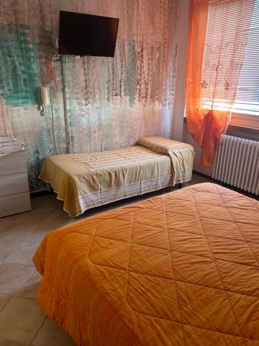 a bedroom with two beds and a tv on the wall at Albergo La Grolla in Antey-Saint-André