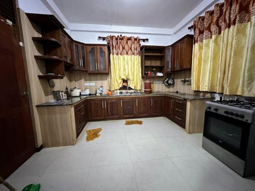 a kitchen with wooden cabinets and a stove at Naturus Villa Thalpitiya in Panadura