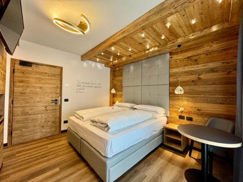 Un dormitorio con una cama y una mesa. en B&B Cèsa Planber Mountain View BIKE FRIENDLY, en Canazei