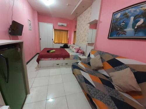 una camera con un letto e un divano di Apartemen SUKARNO HATTA Elwarda Ely a Malang