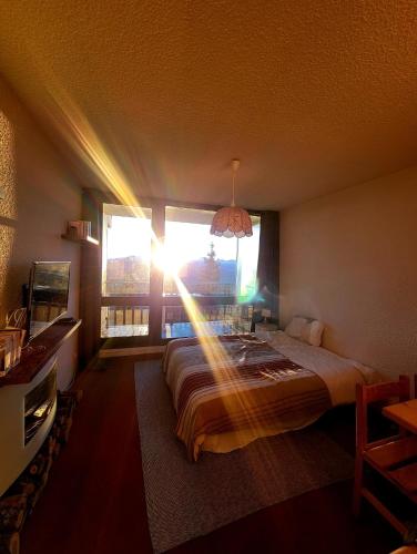 une chambre avec un lit dans une pièce avec une fenêtre dans l'établissement Studio 05 Saint Honoré 1500, Vue montagne et lac, 2 personnes, Série Anthracite Netflix, à Saint-Honoré