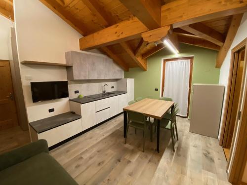 a kitchen with a wooden table and a kitchen with a sink at Residence Arnica in Celledizzo