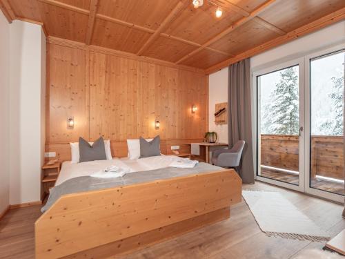 ザンクト・ヤーコプ・イン・デフェルエッゲンにあるHaus Beckenの木製の壁のベッドルーム1室(大型ベッド1台付)