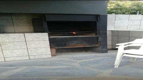 a fire place with a white chair in front of it at Toti Cabana 58 in Amanzimtoti