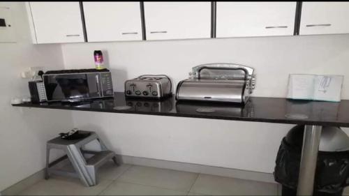 a kitchen counter with a microwave and a toaster oven at Toti Cabana 58 in Amanzimtoti