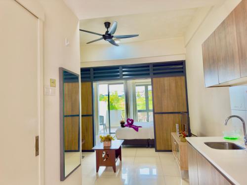 a kitchen with a ceiling fan and a living room at ATS Cameron Hotel & Apartments in Cameron Highlands