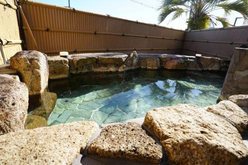 uma grande piscina com pedras num quintal em 白浜・温泉リゾート海岳 em Shirahama