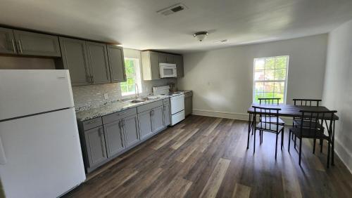 - une cuisine avec des appareils blancs, une table et des chaises dans l'établissement Apartment Retreat, à Roanoke