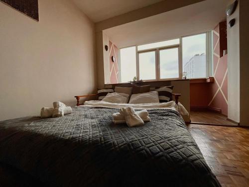 a bedroom with a large bed with two stuffed animals on it at Rustic TrainStation Corner in Braşov