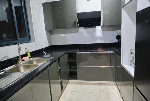 uma cozinha com dois lavatórios e uma bancada preta em The Pearls - Penthouse em East Legon