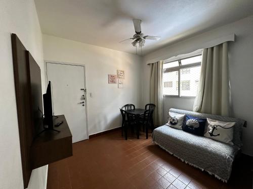 a living room with a couch and a television at Apartamento Boqueirao in Praia Grande