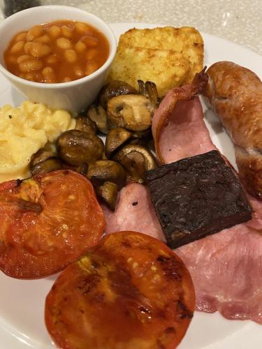 a plate of food with meat potatoes mushrooms and bread at The Hill B&B in Middleton in Teesdale