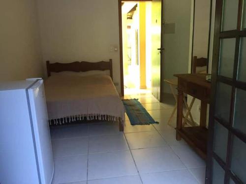sypialnia z łóżkiem, biurkiem i drzwiami w obiekcie Suite 1 a 80 metros do mar de Itamambuca, Ubatuba w mieście Ubatuba