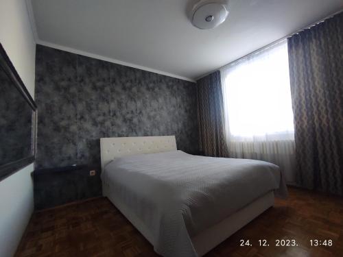 a small bedroom with a bed and a window at Azer in Sarajevo