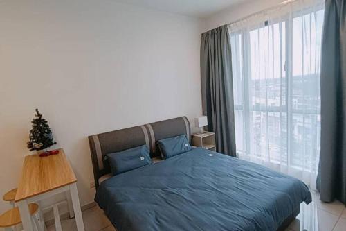 a bedroom with a blue bed and a christmas tree at Cozy Sky Trees Bukit Indah Nflix HBO Disney l Pool B8 in Johor Bahru
