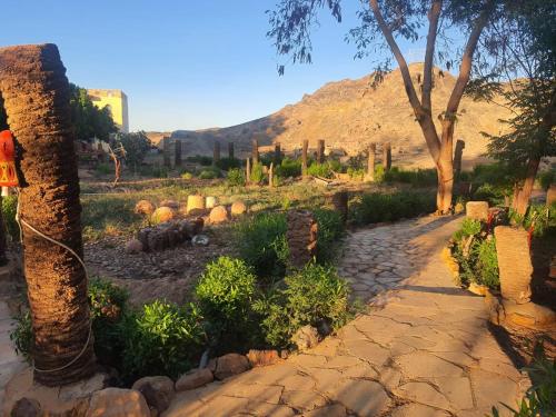 a stone path in a garden with a mountain in the background at Oasis Panorama Hotel in Bawiti