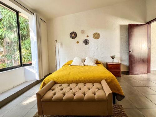 a bedroom with a bed with a yellow blanket at Casa Violetas in Oaxaca City