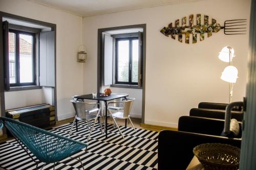 uma sala de estar com mesa e cadeiras em Pensao Sisudo em Sintra