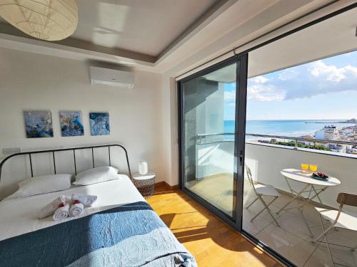 sypialnia z łóżkiem i widokiem na ocean w obiekcie Dios Ponte Finikoudes Beachfront Duplex Penthouse w Larnace