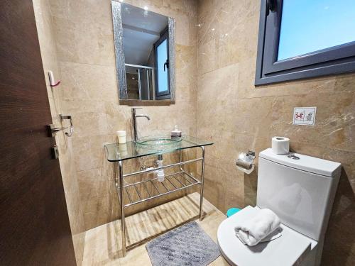 a bathroom with a sink and a toilet at Dios Ponte Finikoudes Beachfront Duplex Penthouse in Larnaka
