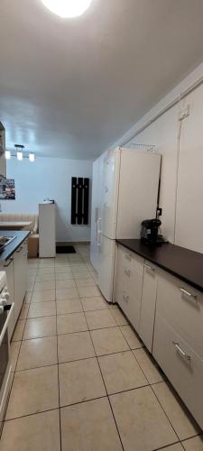 a kitchen with white appliances and a tile floor at Studio BDN in Sîngeorgiu de Mureş