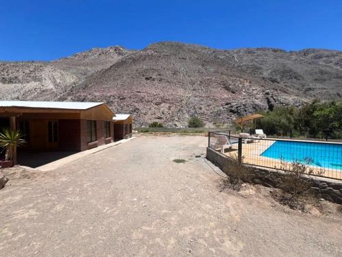 uma casa com piscina em frente a uma montanha em Cabañas Altura de Varillar em Varillar