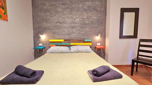 a bedroom with a bed with two purple pillows on it at Aba Maya Alghero in Alghero