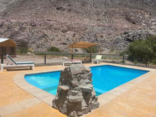 uma piscina com uma rocha em frente a uma montanha em Cabañas Altura de Varillar em Varillar