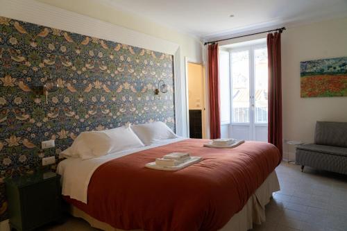 una camera da letto con un grande letto con una coperta rossa di Domus Sibyllina, Palazzo Cavalcanti a Napoli