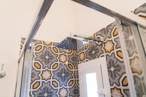 a room with a door and a wall with tiles at Domus Sibyllina, Palazzo Cavalcanti in Naples