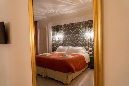 a reflection of a bedroom with a bed in a mirror at Domus Sibyllina, Palazzo Cavalcanti in Naples