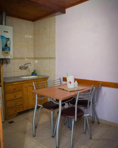 a kitchen with a wooden table and chairs at Hostal "El Tomolasta" in La Carolina
