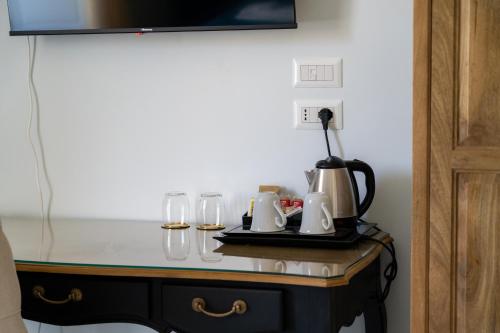 a table with a coffee maker and glasses on it at Domus Sibyllina, Palazzo Cavalcanti in Naples
