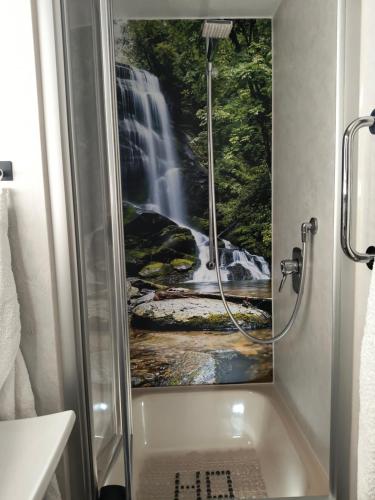 een badkamer met een douche en een watervalschilderij bij Appartement Herrlich in Bad Wildbad