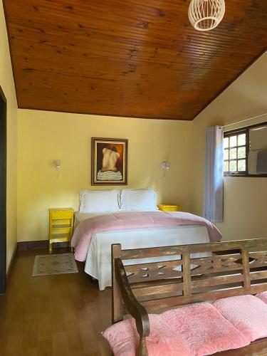 a bedroom with a large bed with a wooden ceiling at VILLA MIA DUO in Itaipava