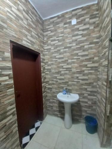 La salle de bains est pourvue d'un lavabo et d'un mur en briques. dans l'établissement Rum Bedouin House, à Disah