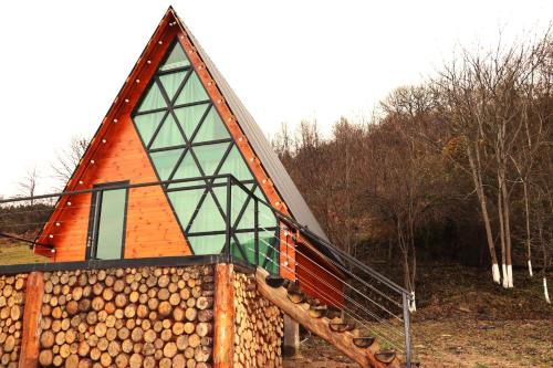 a house with a pile of logs in front of it at Ramona in Ambrolauri
